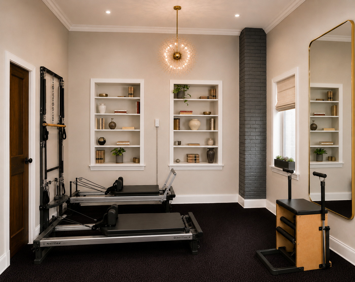 The GLOW Body Pilates studio in Ridgewood, NJ: two Merrithew reformers, a spine corrector and stability chair beneath twelve-foot ceilings, with built-in shelves and a gold-framed mirror